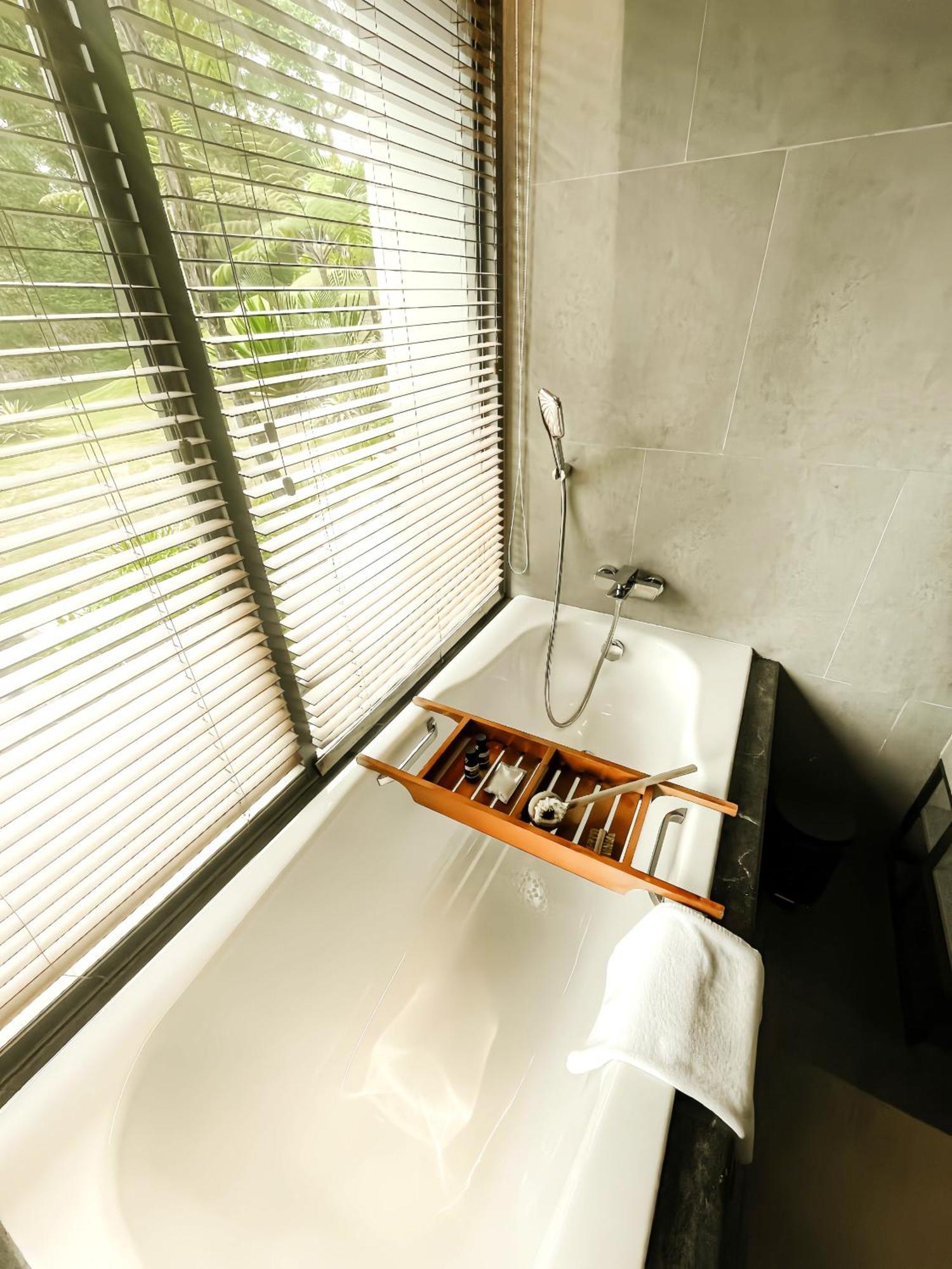 The Botanica Sanctuary Hotel Puncak Værelse billede A bathtub with a shower